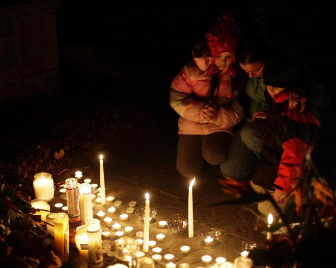 A family pauses at the vigil to remember and grieve. 